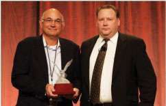 Joe Leffel (left) accepts the 2009 Distributor of the Year Award on behalf of Power Train Service and presented by Derek Smith, editor of Truck Parts & Service (right).