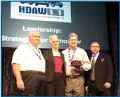 Don Purcell (left) and Keith McLemore, co-owners of Stone Truck Parts, accept the Truck Parts & Service Distributor of the Year award from Truck Parts & Service Executive Editor Denise L. Rondini. Craig Kruckeberg, CEO, Minimizer and the program’s sponsor, was also on hand.