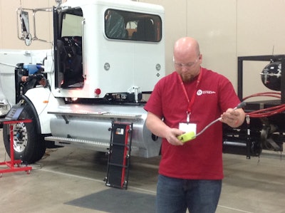 Adam Hillard works with a device that tests for natural gas leaks.