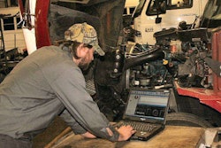 Technician working on laptop in service bay