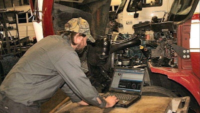 Technician working on laptop in service bay