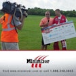 Minimizer’s Craig Kruckeberg donates a check to Kevin Burkart after his Imperfect Jumps event raised $78,000 for Parkinson’s disease patient care and research.