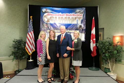 John Minor, center, accepts the CVSN President’s award at the Aftermarket Distribution Summit Monday in Santa Rosa, Calif. with his wife and two daughters.