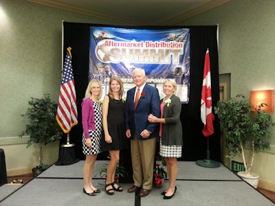 John Minor, center, accepts the CVSN President’s award at the Aftermarket Distribution Summit Monday in Santa Rosa, Calif. with his wife and two daughters.