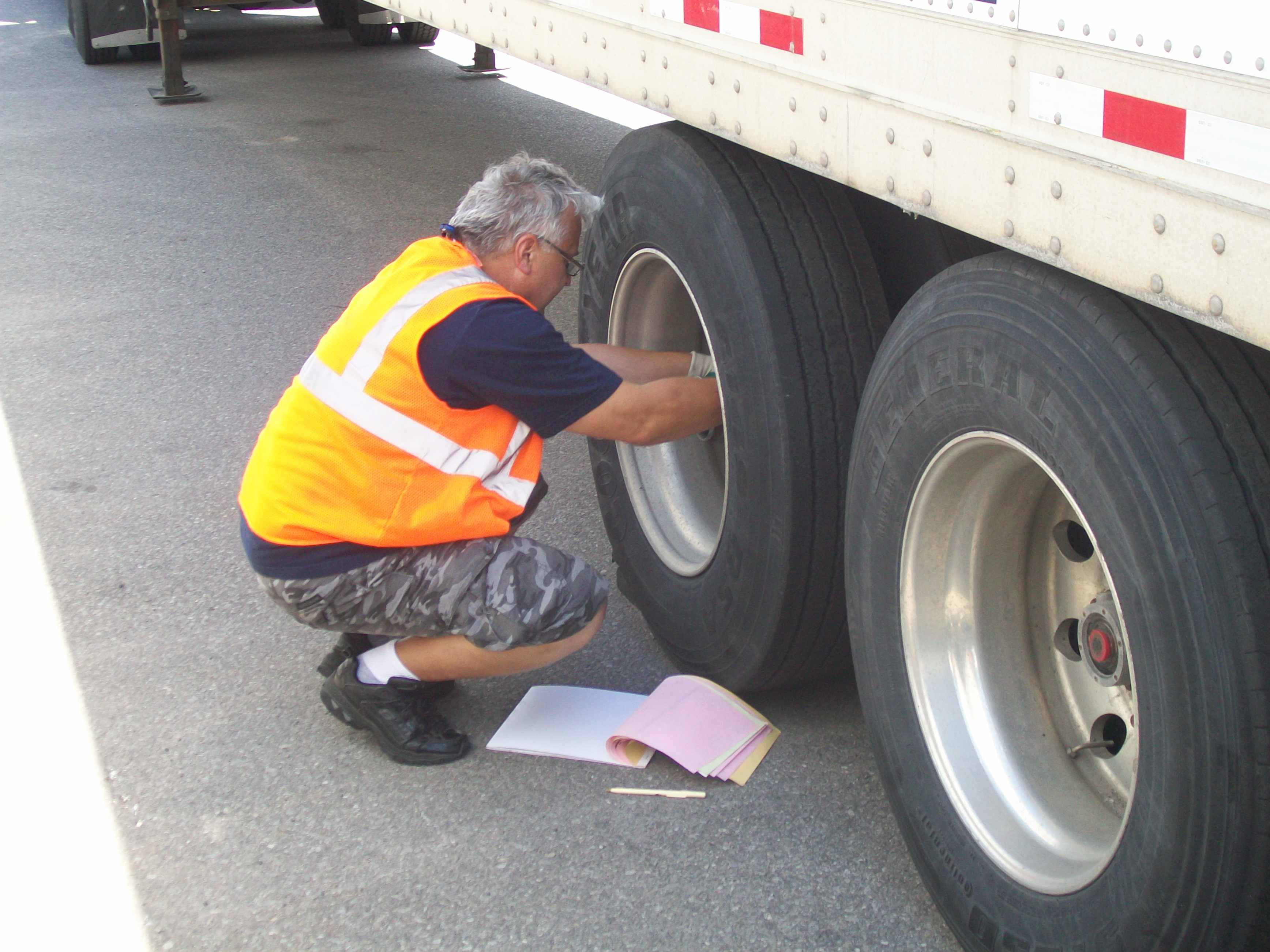 Truck driver checking truck tire