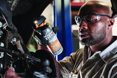 Heavy duty mechanic applying Liquid Wrench to a vehicle