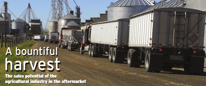Trucks parked near farm silos