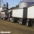 Trucks parked near farm silos
