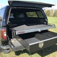 Truck with in-bed sliding tray cargo management systems