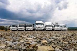 Seven Isuzu commercial trucks parked