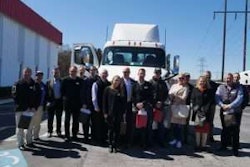 The group of dealer principals and Daimler executives from Australia and Peach State President Rick Reynolds pose in front of a New Cascadia following the Forest Park facility tour.