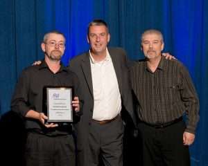 Dean Vicha, NationaLease president (center), presented the Exceptional Service Award to 12 NationaLease members. Shown above are recipients Randy Johnson (right) and Eric Poppe (left), both of Kirk NationaLease.