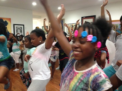 Young ladies demonstrate a yoga position during Bailey’s Café’s six-week free arts-based summer program for young people ages 9 to 19.