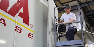 Technician making repairs to truck trailer.