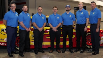 The Penske Truck Leasing Tech Showdown competition featured about 1,300 Penske technicians and customer service representatives across North America. Here are the top five competitors in the exhaust stream management event, with senior leaders, from left: Gregg Mangione, senior vice president of maintenance; Brenden Waggy, third place; Stanley Lindler, second place; David Sledziewski, first place; Dan Ferrer, fourth place; Mark Parisotto, fifth place; Art Vallely, president.