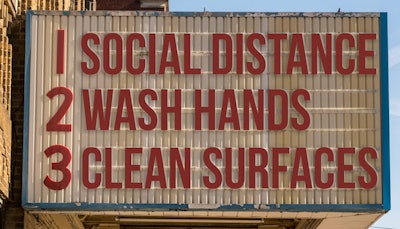 Social distance, wash hands, clean surfaces on a theatre sign