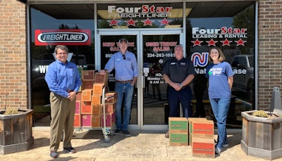 Jerry Kocan, Four Star Freightliner dealer principal (left to right); Sonny Hartley, service advisor; Judson Coburn, parts manager; accept Girl Scout cookie donations from Alicia G. Schneider, Girl Scouts of Southern Alabama chief development officer.