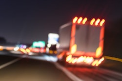 Truck on the road at night with lights on