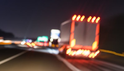 Truck on the road at night with lights on