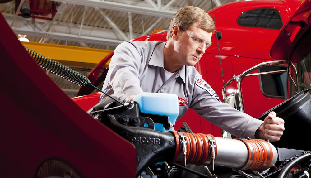 Peterbilt service technician works on engine