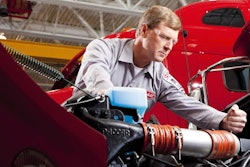 Peterbilt service technician works on engine