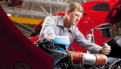 Peterbilt service technician works on engine