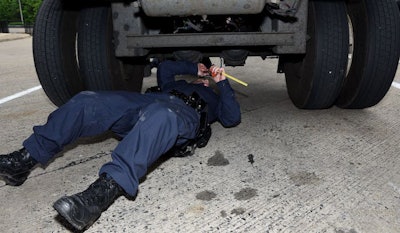 An inspector hard at work performing a brake inspection during a prior CVSA Brake Safety Week.