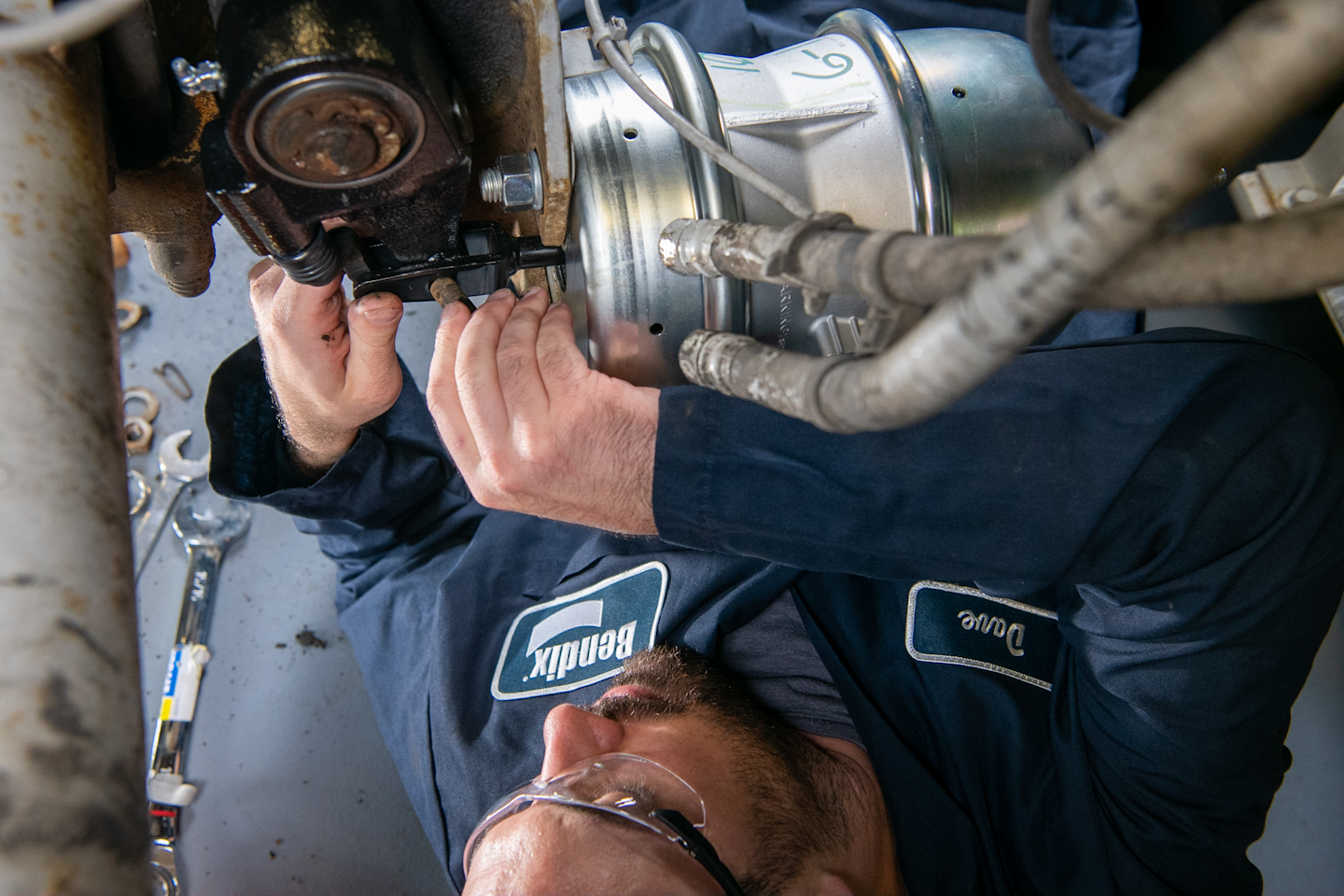 A tech works under a Bendix automatic slack adjuster. “If a wheel-end equipped with an automatic slack adjuster is out of adjustment, Bendix’s first – and most important – piece of advice is this: Do not manually adjust the adjuster. Instead, investigate why the brake is over the stroke limit,” says Keith McComsey, Bendix Spicer Foundation Brake director of marketing and customer solutions – wheel-end.