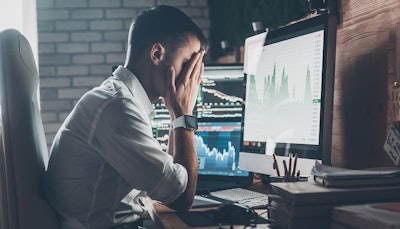 frustrated worker sits at iMac