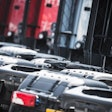 rear new of row of semi trucks without trailers