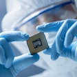 worker holding Semiconductor chip with gloves and safety gear