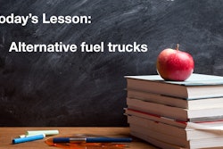 Today's Lesson: Alternative fuel trucks on a chalkboard behind a stack of books with an apple