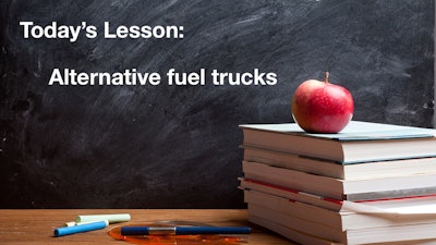 Today's Lesson: Alternative fuel trucks on a chalkboard behind a stack of books with an apple