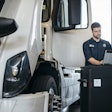 Volvo Technician working on a tablet beside a semi-truck