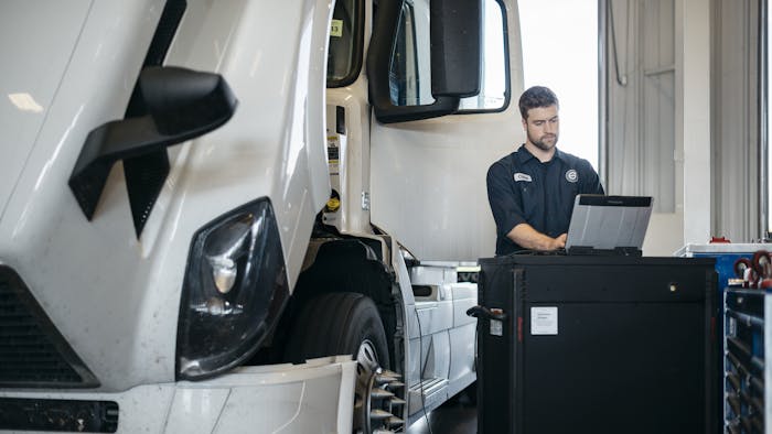 Volvo Technician working on a tablet beside a semi-truck