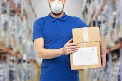 Employee wearing mask carrying boxes