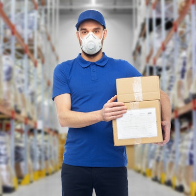 Employee wearing mask carrying boxes