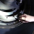 Tech checking dimensions of a brake drum