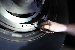 Tech checking dimensions of a brake drum