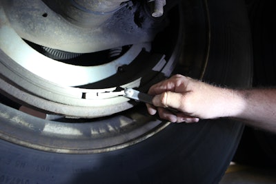 Tech checking dimensions of a brake drum