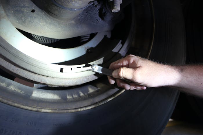 Tech checking dimensions of a brake drum