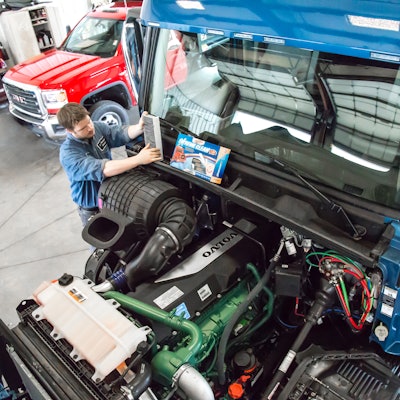 Technician installing a filter in truck.