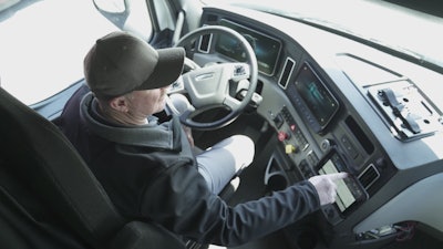 Technician checking truck data on dashboard.