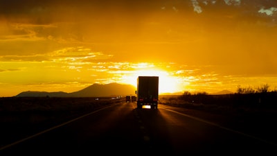 Truck driving into sun