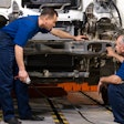 Two technicians repairing a truck.