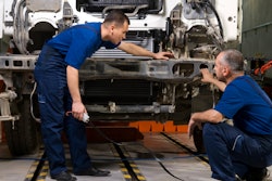 Two technicians repairing a truck.