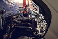 Truck technician working on truck engine