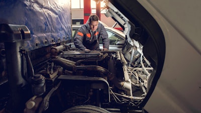 Truck technician working on truck engine