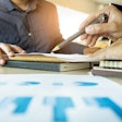 Two people going over documents at a desk