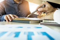 Two people going over documents at a desk